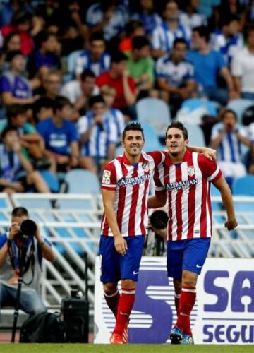 El centrocampista del Atlético de Madrid Koke, celebra con David Villa su gol, segundo del equipo, durante el partido de la tercera jornada de Liga en Primera División que disputan Real Sociedad y Atlético de Madrid esta tarde en el estadio de Anoeta, en San Sebastián.