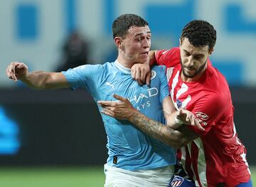 Phil Foden y  Mario Hermoso pelean por la disputa de un balón.