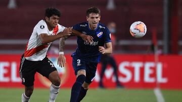 JJPANA8518. BUENOS AIRES (ARGENTINA), 10/12/2020.- Robert Rojas (i) de River disputa un bal&oacute;n con Renzo Orihuela de Nacional hoy, en un partido de los cuartos de final de la Copa Libertadores entre River Plate y Club Nacional en el estadio Libertad