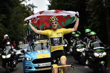 El ciclista del Sky Geraint Thomas alza la bandera de Gales.