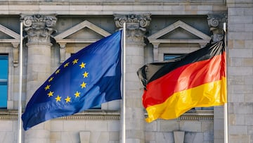The flags of the European Union and Germany wave in front of the German parliament in Berlin, close up
