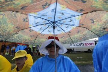 Espectadores se protegen de la lluvia.