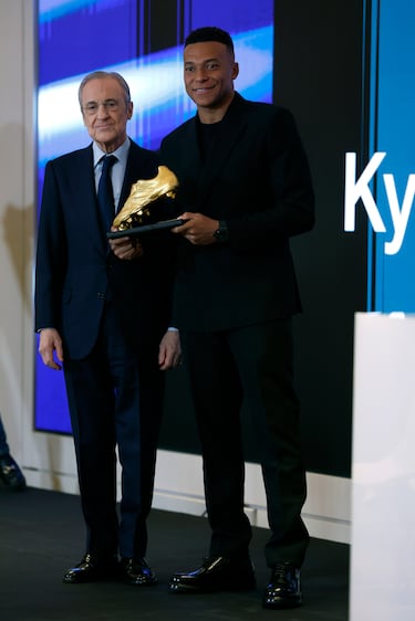 El delantero francés del Real Madrid Kylian Mbappe posa junto al presidente del club, Florentino Pérez, tras recibir este viernes la Bota de Oro en un acto celebrado en el palco del Santiago Bernabéu.