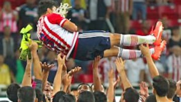 Omar Bravo es cargado por sus compañeros mientras sostiene el cacho de red que guardará como recuerdo de este histórico momento.