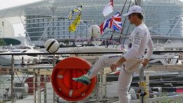 Nico Rosberg juega al fútbol delante de los yates en el circuito de Yas Marina.