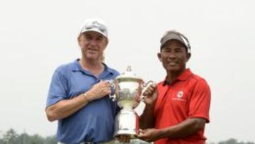 Miguel Angel Jimenez (capitán del equipo de Europa) sostiene la copa junto a Thongchai jaidee (capitán del equipo de Asia).