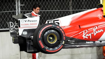 El piloto español de Ferrari, Carlos Sainz, observa cómo se llevan su monoplaza tras el percance con la tapa de alcantarilla.