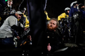 Un hombre observa mientras la polica se enfrenta a los fanticos que se reunieron para celebrar despus del triunfo de los Philadelphia Eagles.