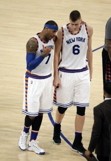 Carmelo Anthony conversa con su compañero Kristaps Porzingis.