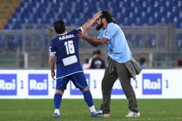 ROM01. ROMA (ITALIA), 12/10/2016.- Un hombre entra al campo de juego y saluda a la leyenda del fútbol argentino Diego Armando Maradona (i) durante un partido de beneficencia 'Partido de la Paz- Unidos por la Paz' hoy, miércoles 12 de octubre de 2016, que es promovido por la fundación Escuelas del Encuentro, una organización impulsada por el papa Francisco, en el estadio Olímpico en Roma (Italia).