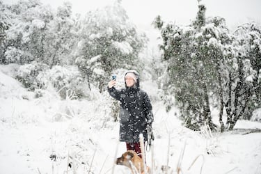 Una mujer se hace una foto en la nieve en Madrid. La Agencia Estatal de Meteorología (Aemet) ha activado el aviso amarillo para hoy por posibles nevadas en la Sierra de Madrid y la zona Metropolitana y Henares, a la par que ha sumado el aviso por fuertes rachas de viento también a la comarca Sur, Vegas y Oeste de la región.