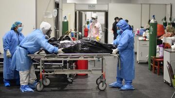 Medical personnel remove the corpse of a Covid-19 victim from the specialized ward at the Honorio Delgado Hospital in Arequipa, late on June 18, 2021, following the sprouting cases of the deathly Delta strain. - People of Arequipa rejects the governmentx92s disposition of a biological fence around the city, which will go into effect next Monday 21 -for fifteen days- and will control the mobility of air, land and rail transport, in a region with a population of 1.3 million inhabitants. (Photo by Diego Ramos / AFP)