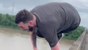 Un chico salta desde un puente al agua. 