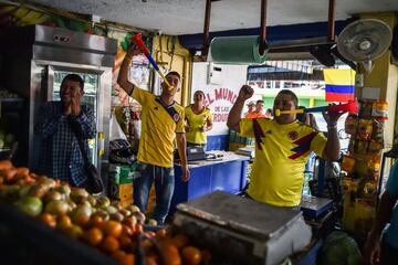 Los aficionados colombianos celebran el gol de la victoria dentro de un popular mercado de Cali.