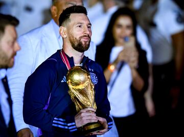 Lionel Messi sosteniendo el trofeo que le otorga como campeón del mundo de fútbol.