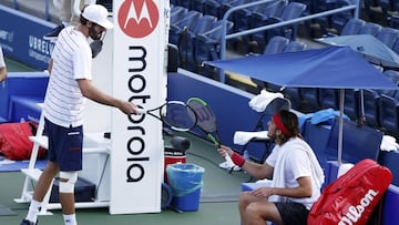 Opelka y Tsitsipas se saludan guardando la distancia.