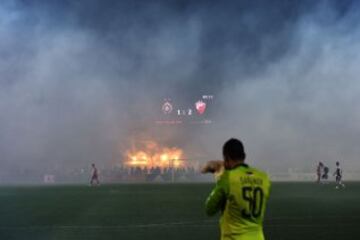 Players wait for the smoke dissipates from the pitch after supporters burnt torches during the Serbian National soccer league derby match between Partizan and Red Star, in Belgrade on February 27, 2016. Red Star won 1-2 at the 150th edition of the 'Eterna