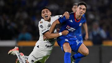Pumas' Argentine midfielder Leo Suarez (L) and Cruz Azul's Argentine midfielder Lorenzo Faravelli fight for the ball during their Mexican Clausura tournament quarterfinal first leg football match between Pumas and Cruz Azul at the Olimpico Universitario stadium in Mexico City on May 9, 2024. (Photo by ALFREDO ESTRELLA / AFP)