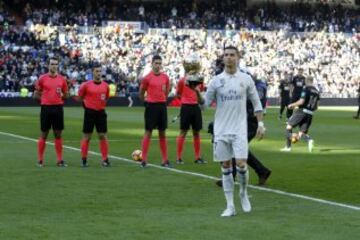 Cristiano ofrece a la grada del Santiago Bernabéu su cuarto galardón como mejor futbolista del mundo.