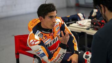 Marc Márquez comentado con su fisio en el box.