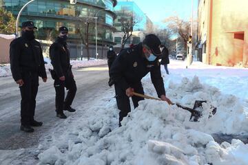 Policia Nacional ayudando en las labores de retirada de nieve por las calles de Madrid. 