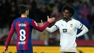 BARCELONA, 29/04/2024.- Los jugadores del FC Barcelona, Pedri y del Valencia, el portugués Thierry Correia, se saludan a la finalización del partido de la jornada 33 de Liga en Primera División que FC Barcelona y Valencia CF han disputado este lunes en el Estadio Olímpico Lluis Companys. EFE/Enric Fontcuberta.
