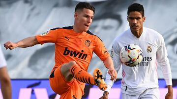 Valencia's French forward Kevin Gameiro challenges Real Madrid's French defender Raphael Varane (R) during the Spanish league football match between Real Madrid and Valencia at the Alfredo di Stefano stadium in Valdebebas on the outskirts of Mad
