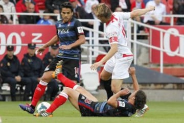 El centrocampista croata del Sevilla Ivan Rakitic (d) y los jugadores del Granada José Luis García Del Pozo "Recio" y Manuel Rolando Iturra luchan por el balón.