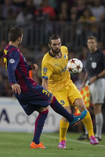 El delantero irlandés del Apoel Cillian Sheridan (d) lucha un balón con el defensa del FC Barcelona Gerard Piqué (i), durante el partido de la primera jornada del Grupo G de Liga de Campeones, disputado esta noche en el Camp Nou. 