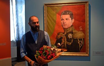 El artista italiano Fabrizio Birimbelli posa delante del retrato de Cristiano Ronaldo en la presentación de su colección de retratos "Como los dioses". El proyecto artístico se compone de una serie de retratos clásicos de las leyendas del fútbol y de las