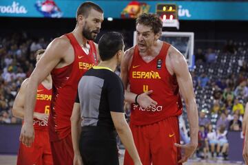 Marc y Pau Gasol discuten con el árbitro durante el encuentro.