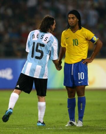 Ronaldinho toma la mano de Messi