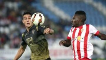 El defensa chileno del Elche, Enzo Roco, disputa un balón con el delantero francés del Almeria, Thievy, durante el encuentro correspondiente a la séptima jornada de primera división, que disputan esta noche en el estadio Juegos del Mediterraneo de Almeria.