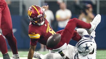 Oct 19, 2025; Arlington, Texas, USA; Washington Commanders quarterback Jayden Daniels (5) fumbles the ball defended by Dallas Cowboys linebacker Shemar James (50) during the third quarter of the game at AT&T Stadium. Mandatory Credit: Kevin Jairaj-Imagn Images