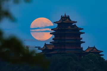 La luna llena aparece en el cielo nocturno sobre la Torre Yuejiang durante las vacaciones del Festival del Medio Oto?o el 17 de septiembre de 2024 en Nanjing, provincia de Jiangsu, China.