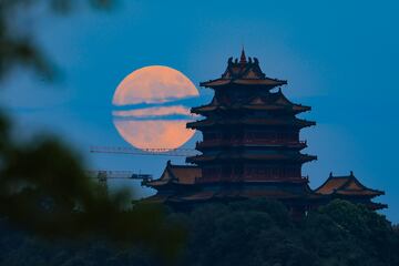 La luna llena aparece en el cielo nocturno sobre la Torre Yuejiang durante las vacaciones del Festival del Medio Otoño el 17 de septiembre de 2024 en Nanjing, provincia de Jiangsu, China.