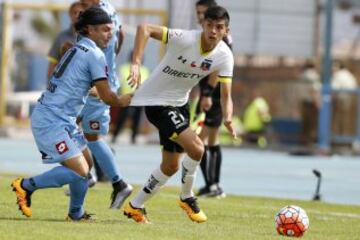 El jugador de Colo Colo, Cristian Gutierrez, centro, disputa el balon con Manuel Villalobos de Deportes Iquique durante el partido de primera division en el estadio Tierra de Campeones de Iquique, Chile.