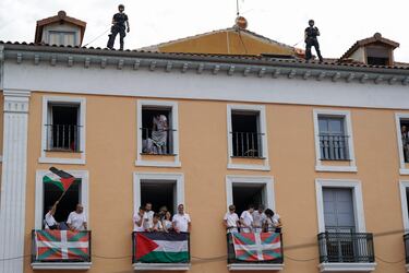 La policía monta guardia en la azotea de un edificio mientras los asistentes se reúnen para celebrar el "Chupinazo" que marca el inicio oficial de las Fiestas de San Fermín en la Plaza Consistorial, frente al Ayuntamiento de Pamplona.