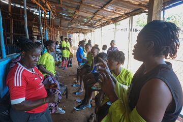 Las integrantes del equipo de f¨²tbol femenino del Centro de Servicios Correccionales se toman un descanso durante el entrenamiento en el campo de f¨²tbol comunitario Parade en Freetown.