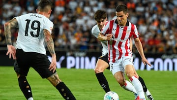 Valencia's Spanish midfielder #08 Javier Guerra (C) challenges Athletic Bilbao's Spanish midfielder #16 Inigo Ruiz de Galarreta during the Spanish league football match between Valencia CF and Athletic Club Bilbao at the Mestalla stadium in Valencia, on September 20, 2025. (Photo by Jose Jordan / AFP)
