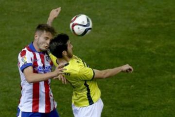 El jugador del L'Hospitalet Ángel Bueno (d) lucha el balón con el centrocampista del Atlético de Madrid Saúl Ñíguez (i) durante el partido de vuelta de los dieciseisavos de final de la Copa del Rey, disputado esta tarde en el estadio Vicente Calderón.