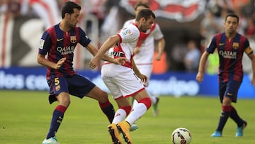 GRA235. MADRID, 04/10/2014.- El delantero brasileño del Rayo Vallecano Leo Baptistao (d) pelea un balón con el centrocampista del Barcelona Sergio Busquets, durante el partido de la séptima jornada de liga en Primera División que se disputa esta tarde en el estadio de Vallecas. EFE/Víctor Lerena RAYO VALLECANO BARCELONA