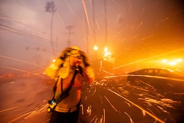 Un bombero lucha contra el incendio de Palisades mientras arde durante una tormenta de viento en el lado oeste de Los ?ngeles.