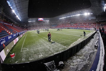 Operarios del club rojillo quitan la nieve del terreno de juego.