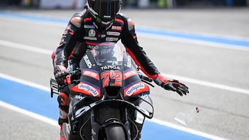 Aprilia Racing's Italian rider Marco Bezzecchi rips a strip off his visor during the free practice 1 session at the Buriram International Circuit in Buriram on February 27, 2026, ahead of the Thailand MotoGP Grand Prix. (Photo by Lillian SUWANRUMPHA / AFP)