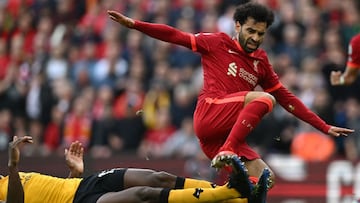 Liverpool's Egyptian midfielder Mohamed Salah is tackled by Wolverhampton Wanderers' French defender Willy Boly (R) during the English Premier League football match between Liverpool and Wolverhampton Wanderers at Anfield in Liverpool, north wes