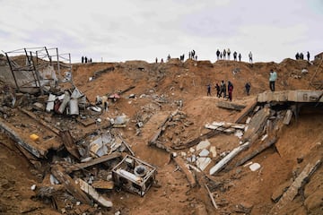 Palestinos inspeccionan los escombros de una estructura impactada por un bombardeo israel en Deir al-Balah, Franja de Gaza.