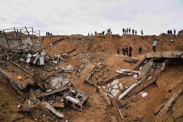 Palestinos inspeccionan los escombros de una estructura impactada por un bombardeo israelí en Deir al-Balah, Franja de Gaza.