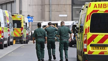 Paramedics walk past ambulances parked outside the Royal London Hospital in east London on January 28, 2021. - Britain on January 26, 2021, became the first European country to pass 100,000 Covid-19 deaths, and is banking on its vaccination drive to beat 
