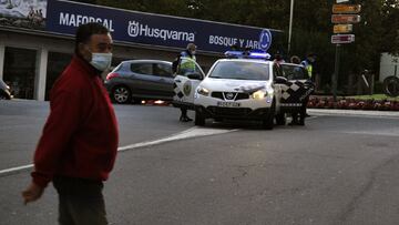 Un hombre pasa al lado de varios agentes durante un control de movilidad en una v&iacute;a de O Carballi&ntilde;o, Ourense, Galicia (Espa&ntilde;a), a 15 de octubre de 2020. Desde hoy, la Xunta limita las entradas y salidas de las localidades orensanas de